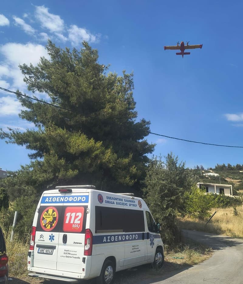 Το ασθενοφόρο της ομάδας, με πυροσβεστικό αεροσκάφος από πάνω